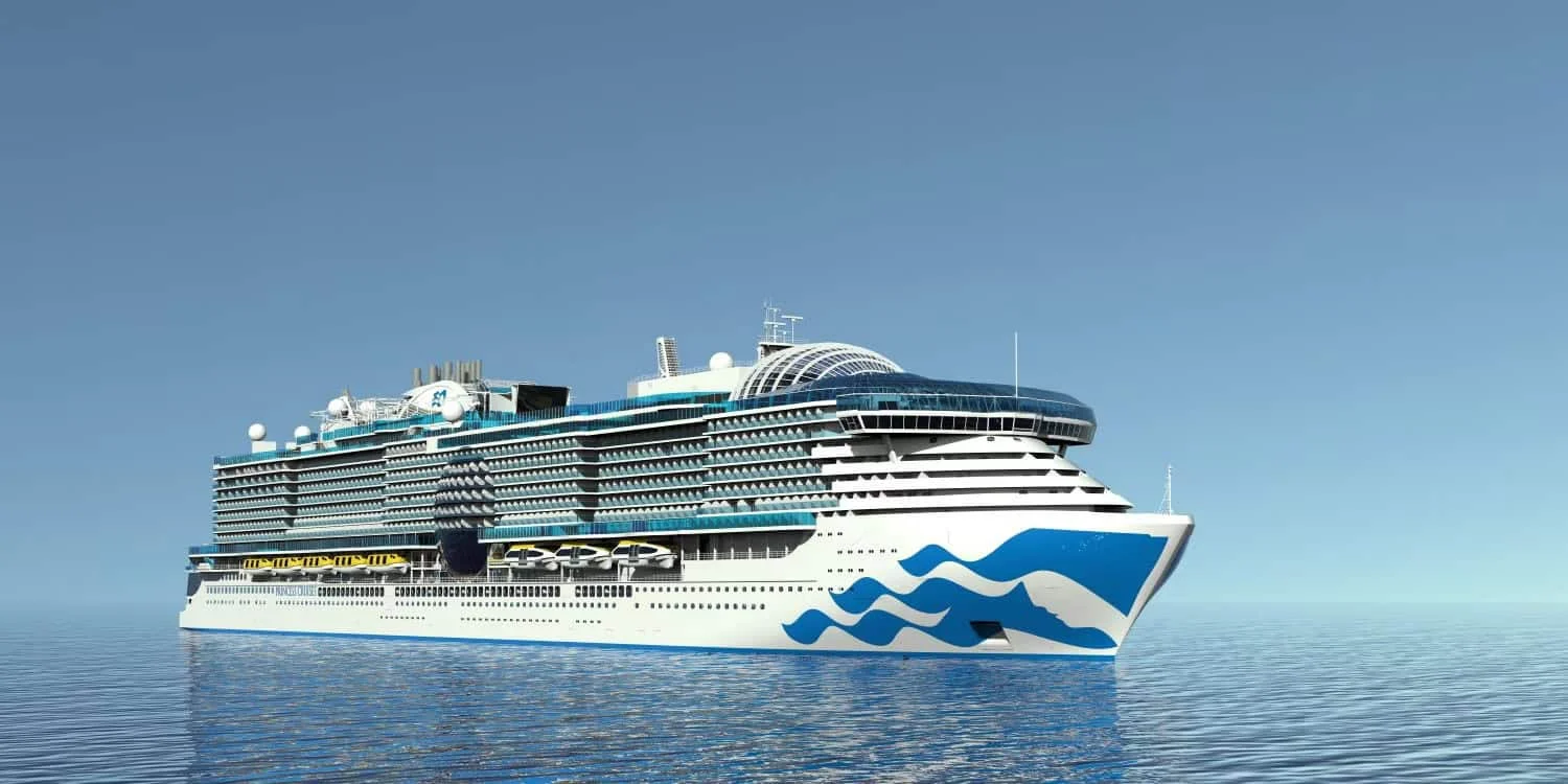 A large white cruise ship with blue wave markings on its hull sailing on calm open water under a clear blue sky.