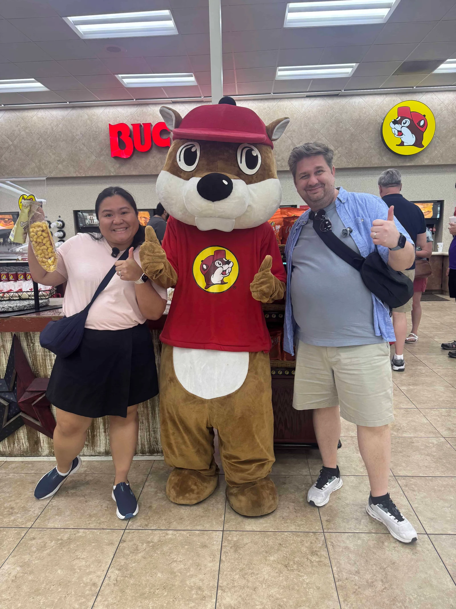 Two people posing with mascot