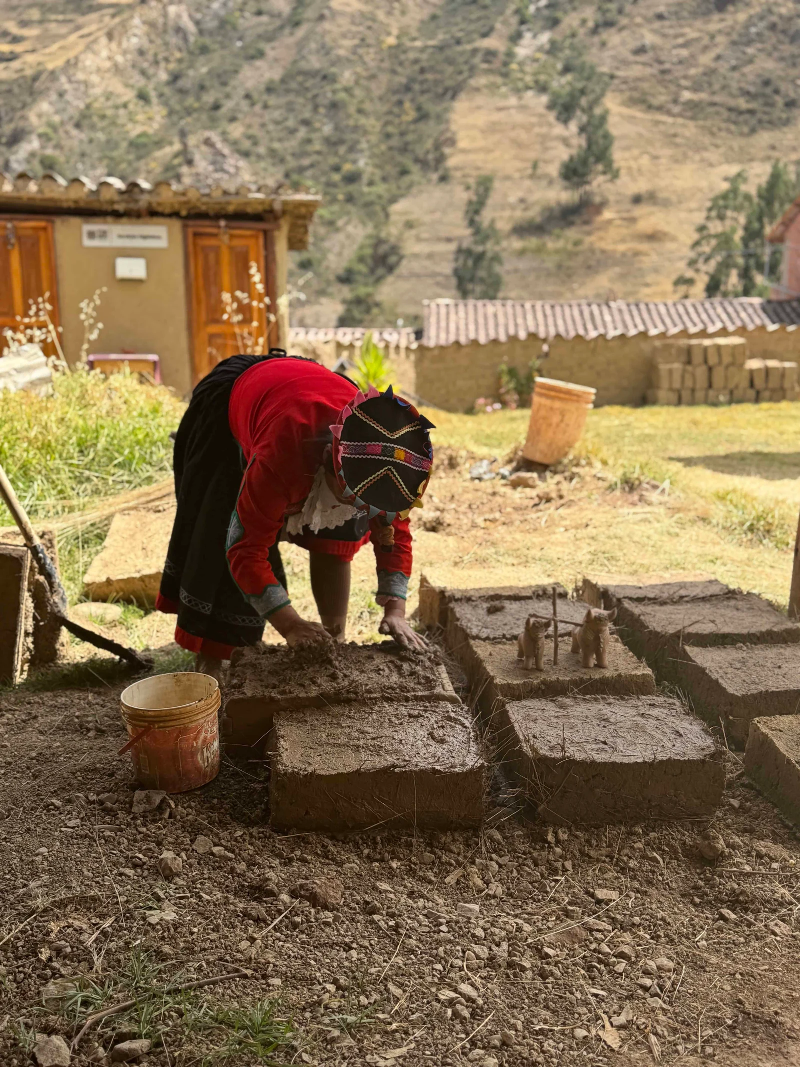 Person making adobe bricks outdoors