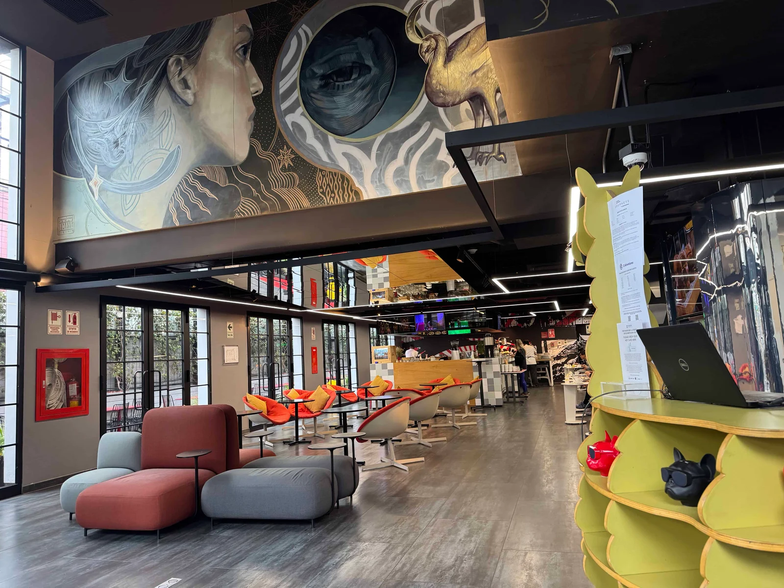 Contemporary hotel lobby featuring artistic mural and cozy seating for guests.