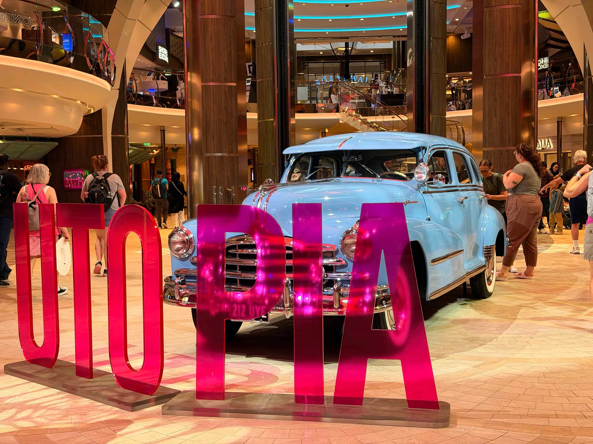 Blue vintage car behind pink letters