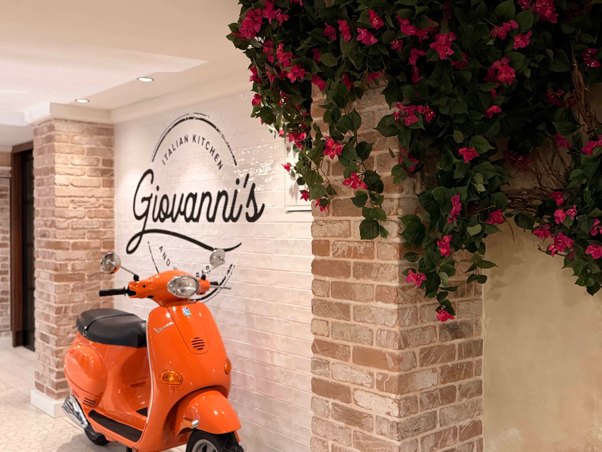 Orange scooter beside brick wall
