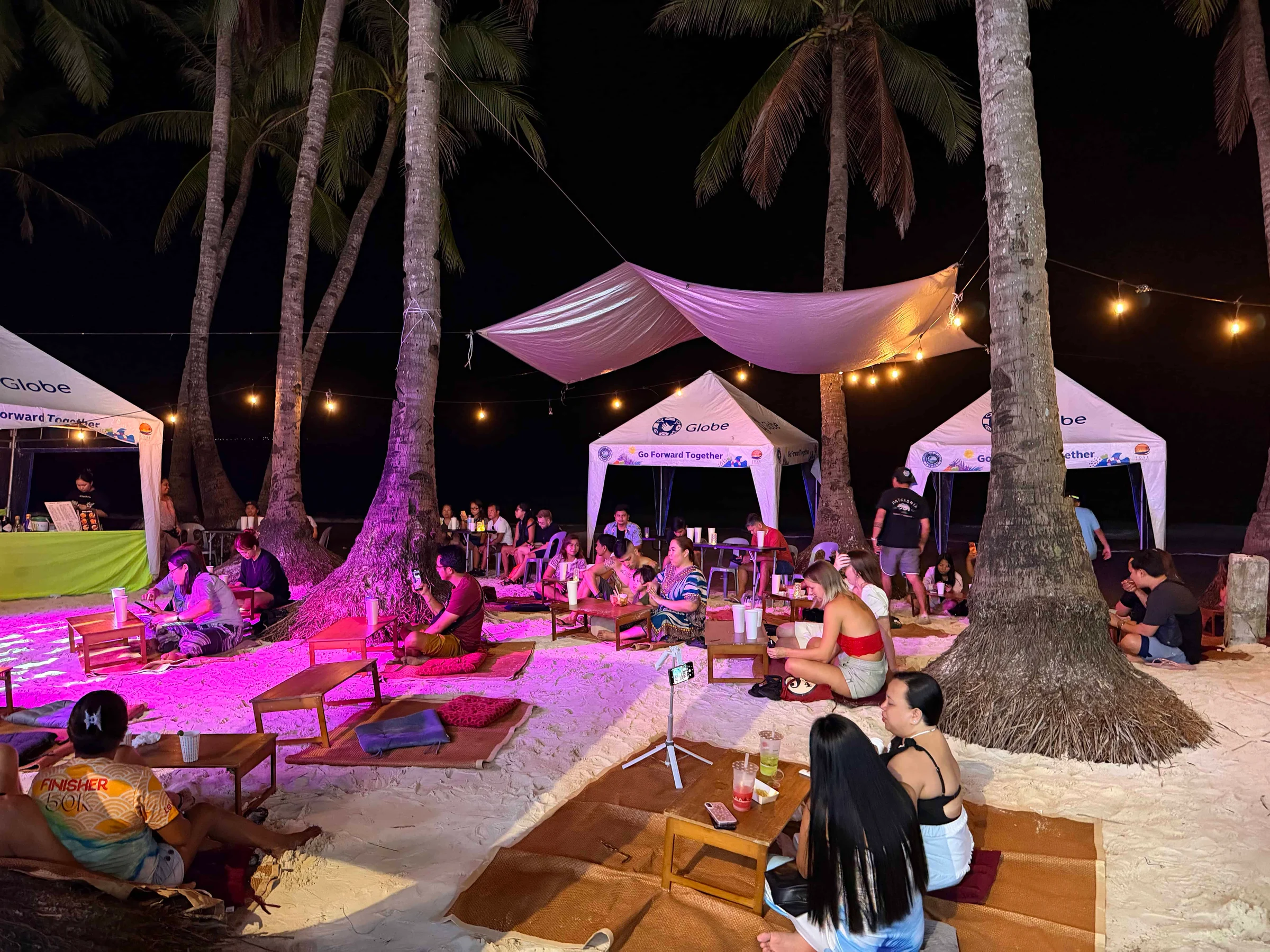 People relaxing at beach night event