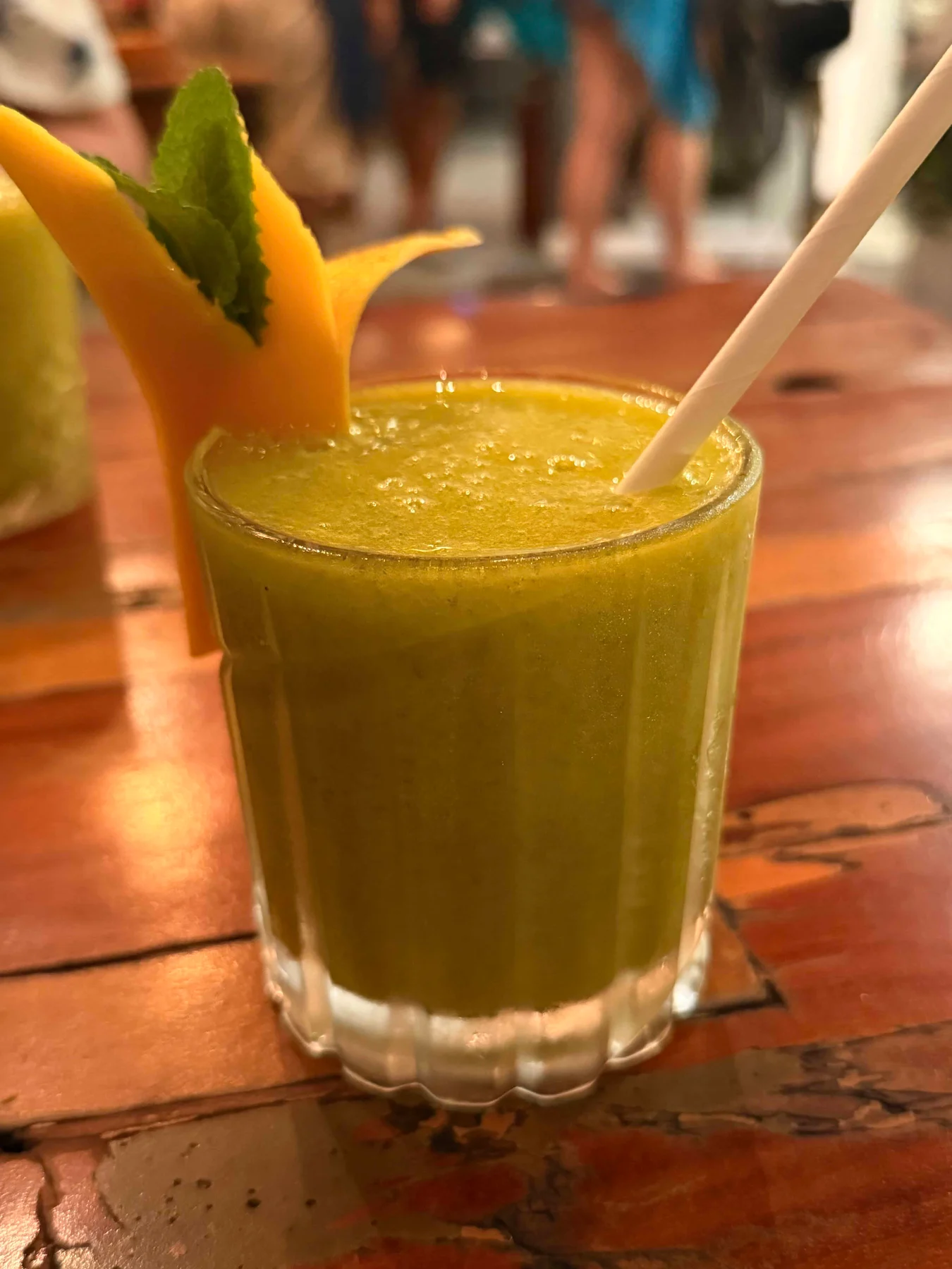 Green smoothie with mango garnish