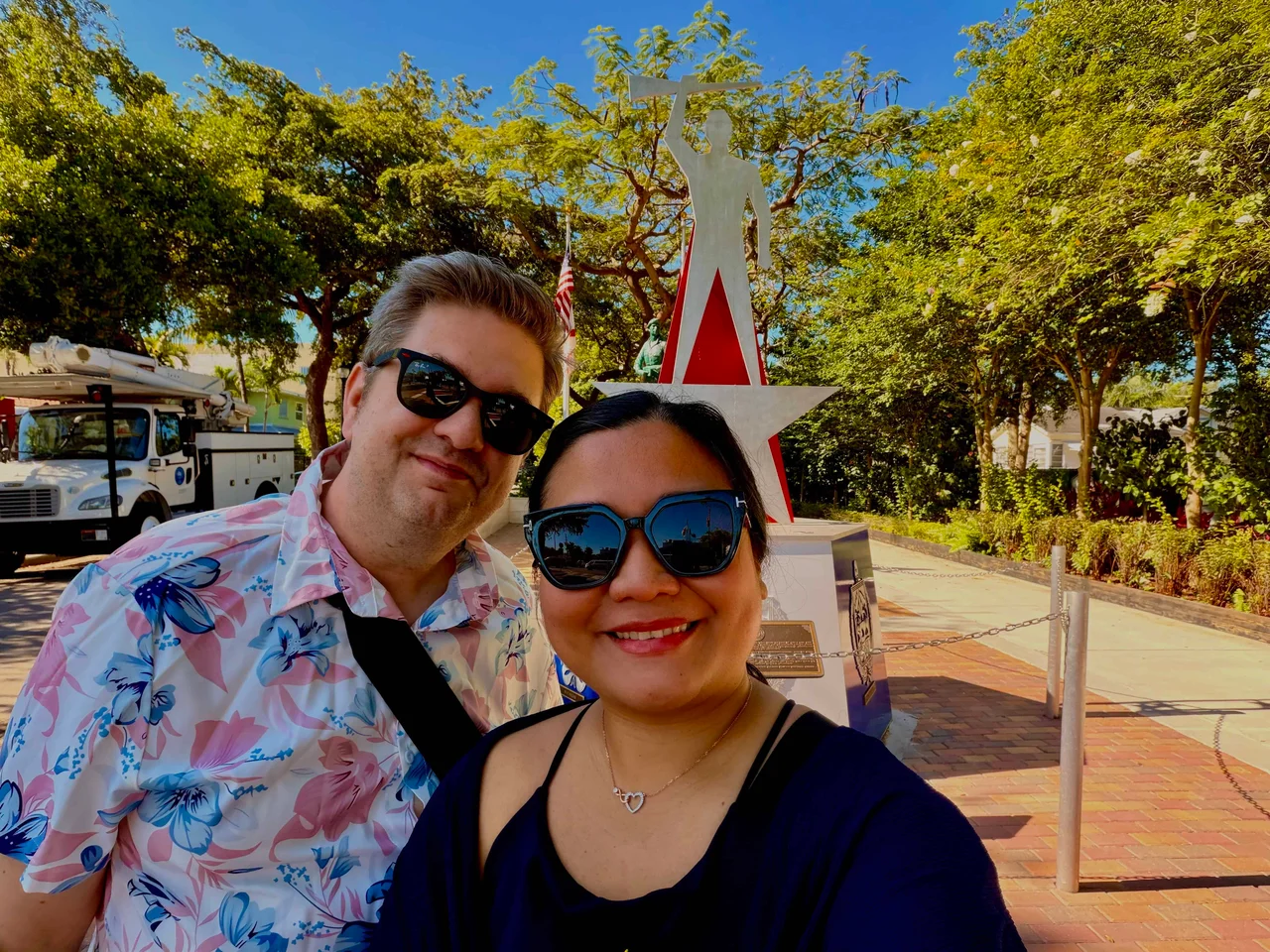 Two people posing near statue