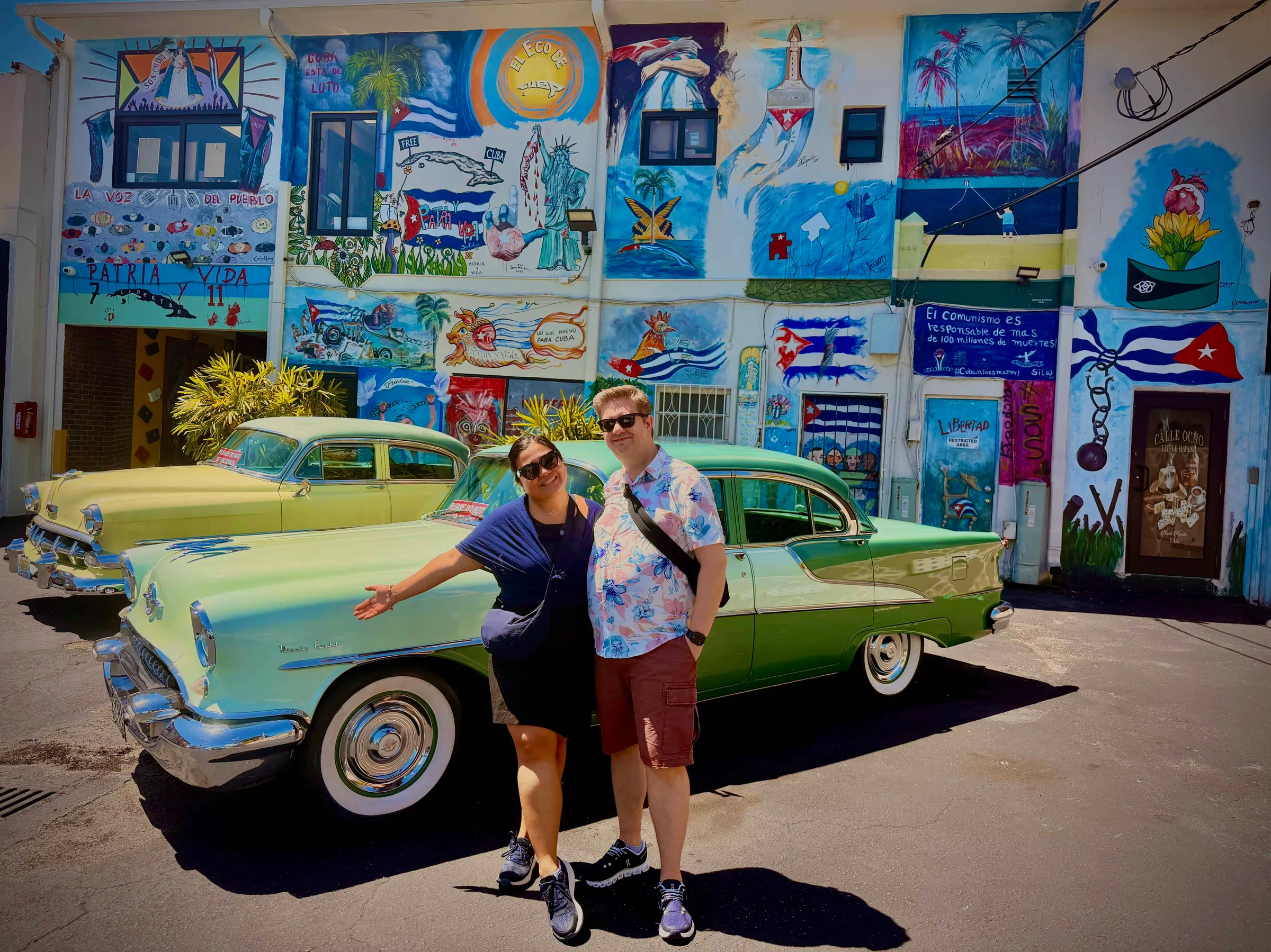 Couple posing with vintage cars