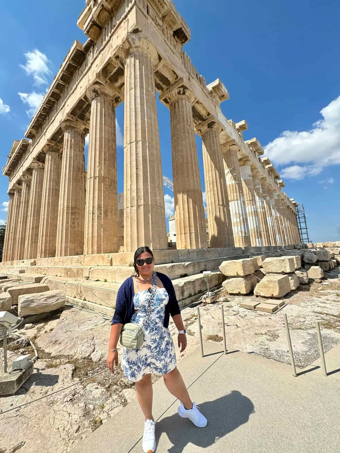 One of us in front of the Parthenon's columns on a sunny day