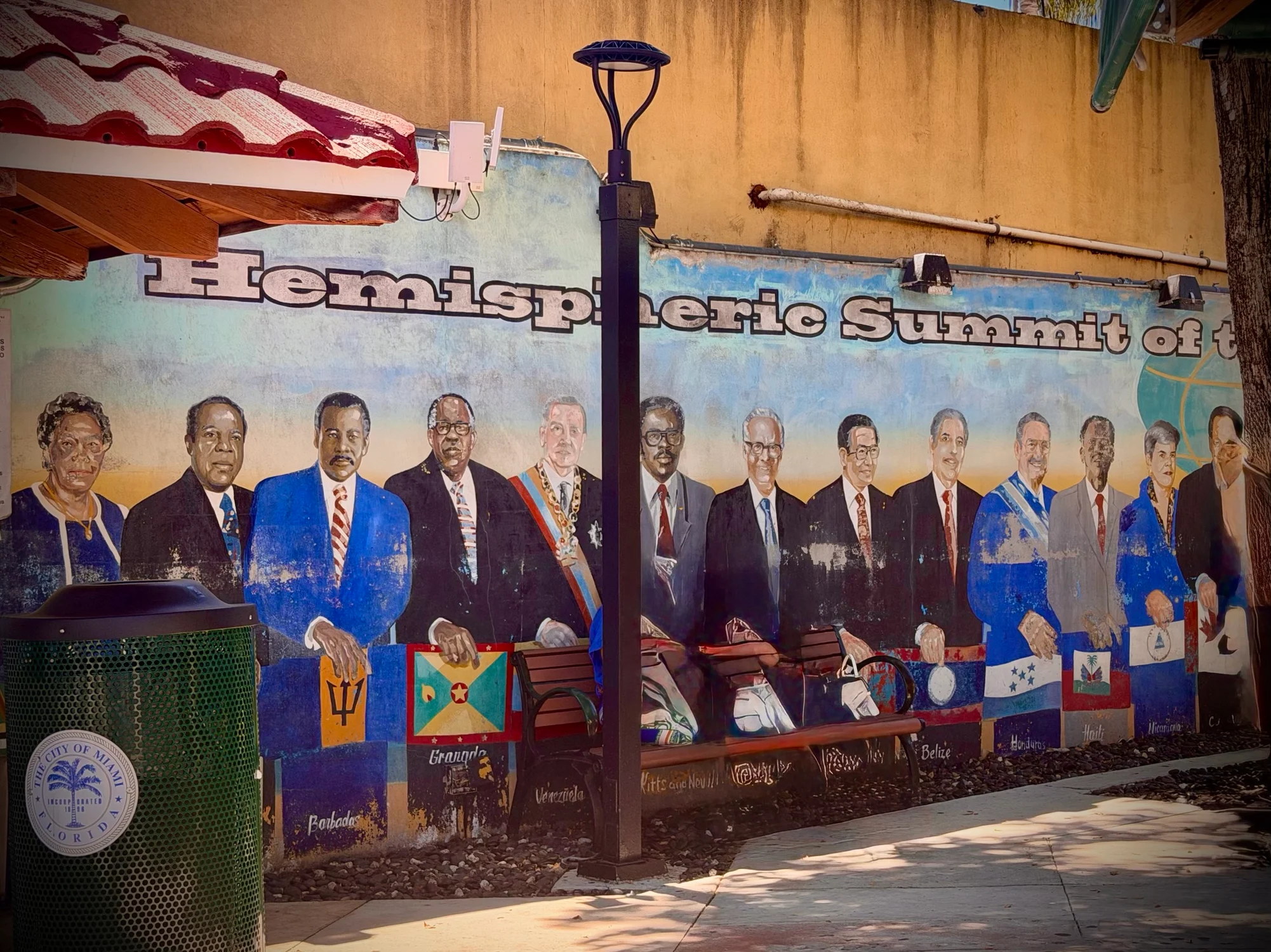 A colourful mural on a wall reads Hemispheric Summit of t, showing a row of painted figures holding national flags