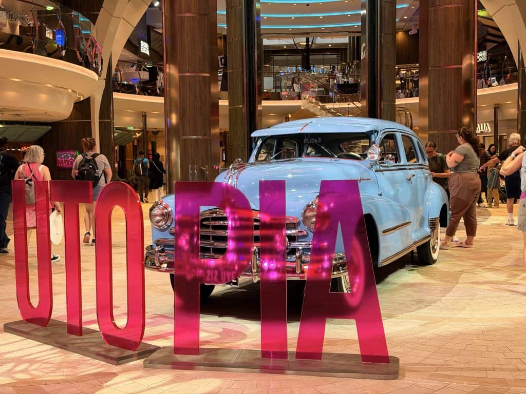 Blue vintage car behind pink letters