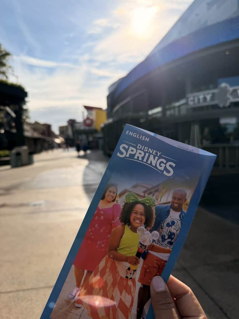 Disney Springs brochure held outdoors