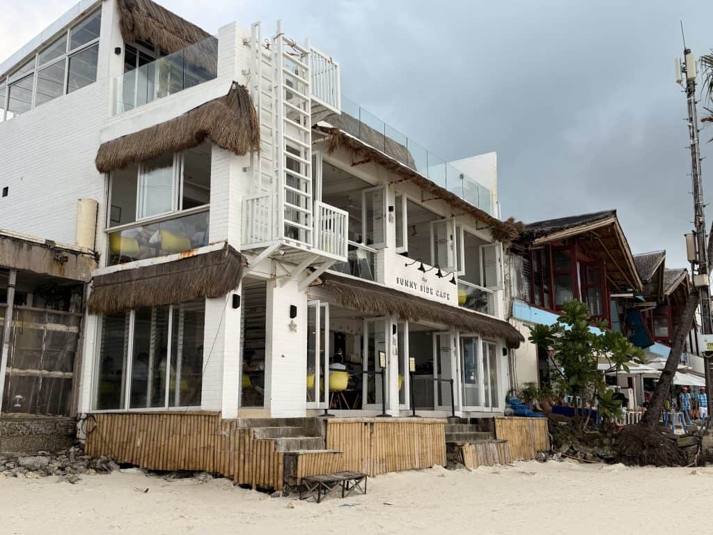 White beachfront café with thatched roof