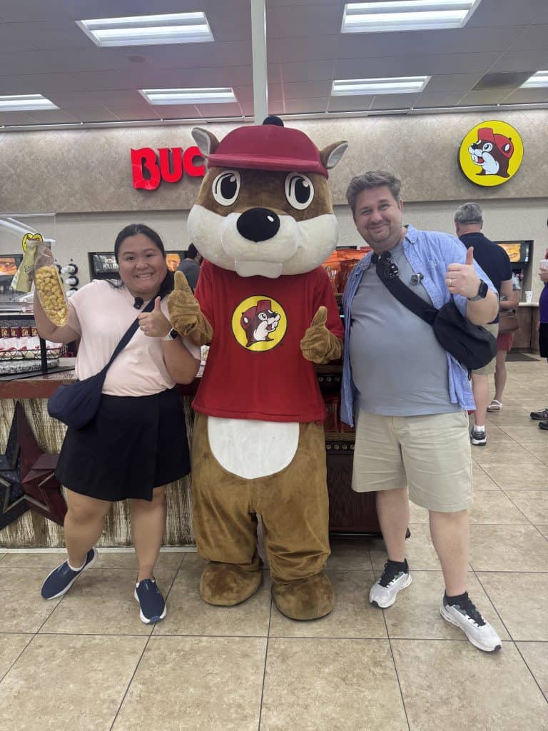 Two people posing with mascot
