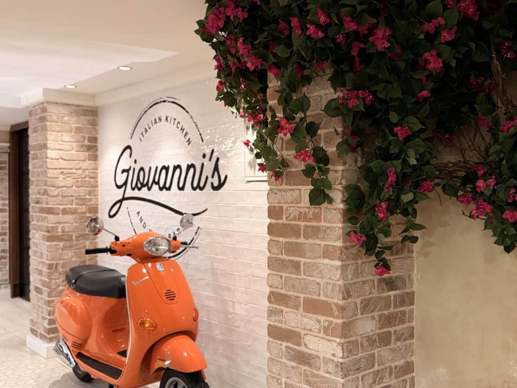 Orange scooter beside brick wall