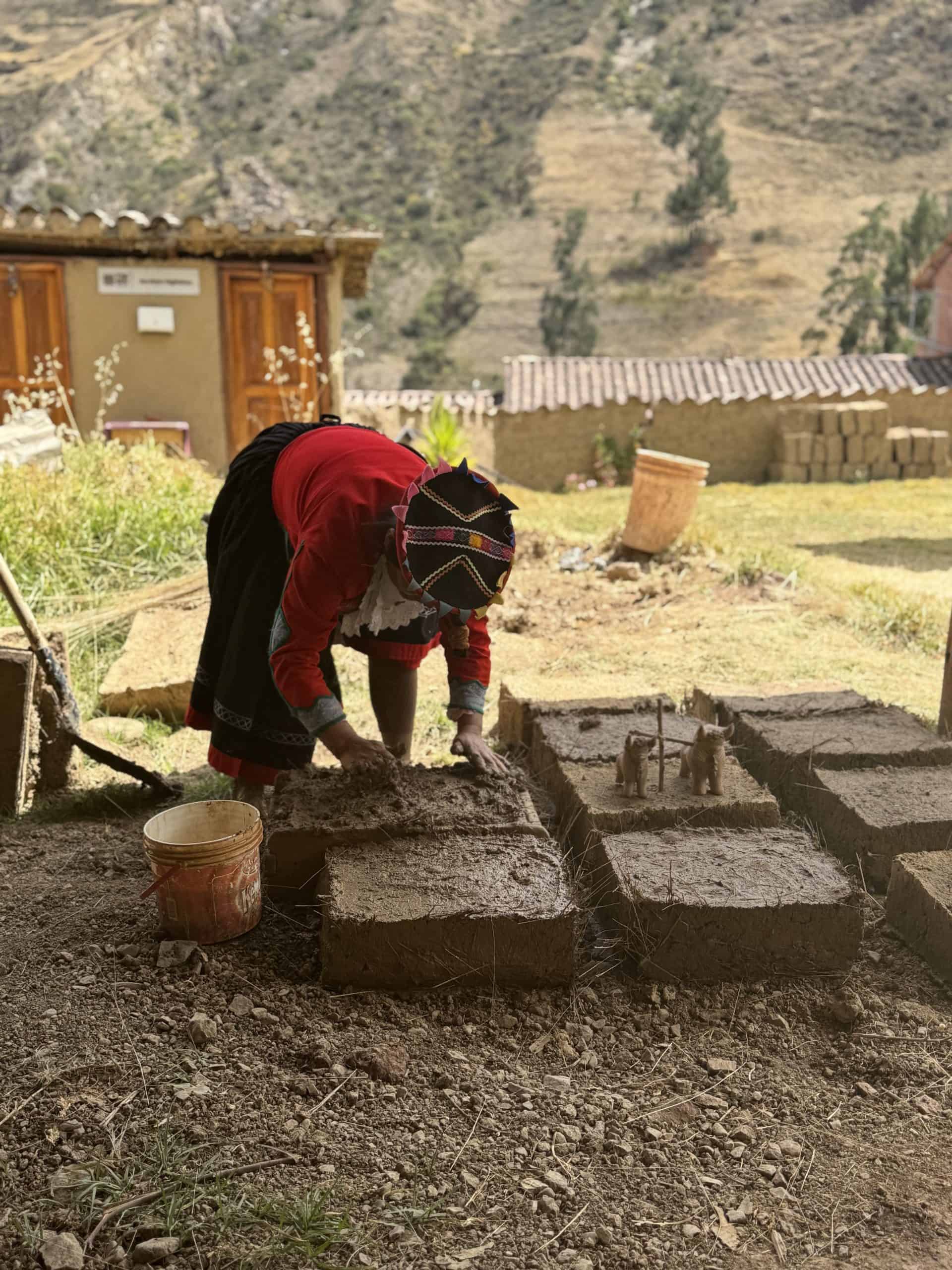 Person making adobe bricks outdoors